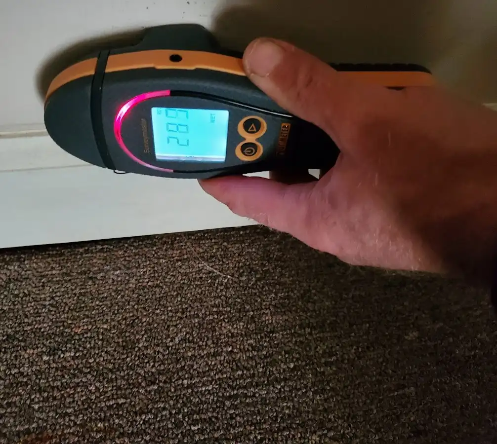 Moisture detection at baseboard during Storm Damage Restoration in Denison